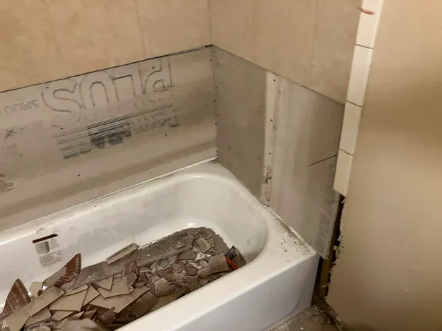 Bathroom demo — tub filled with removed tile debris