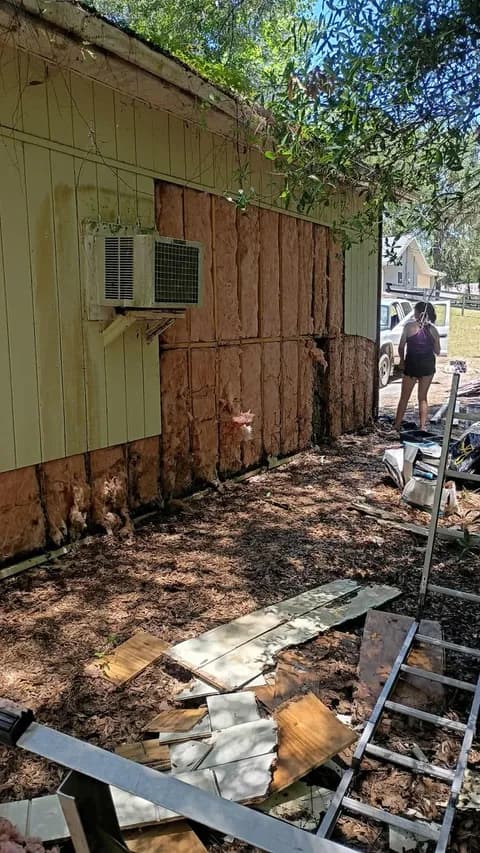 Garage wall opened up — rotted siding removed exposing insulation and framing
