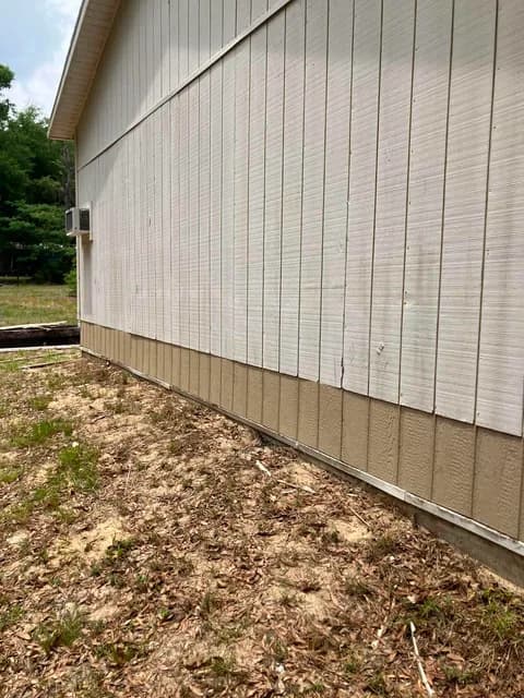 Detached garage before — aged, stained vertical siding along the side wall