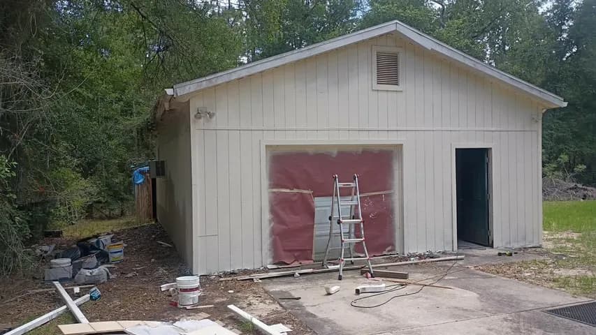 Garage front during siding replacement — new sheathing going in over the opening