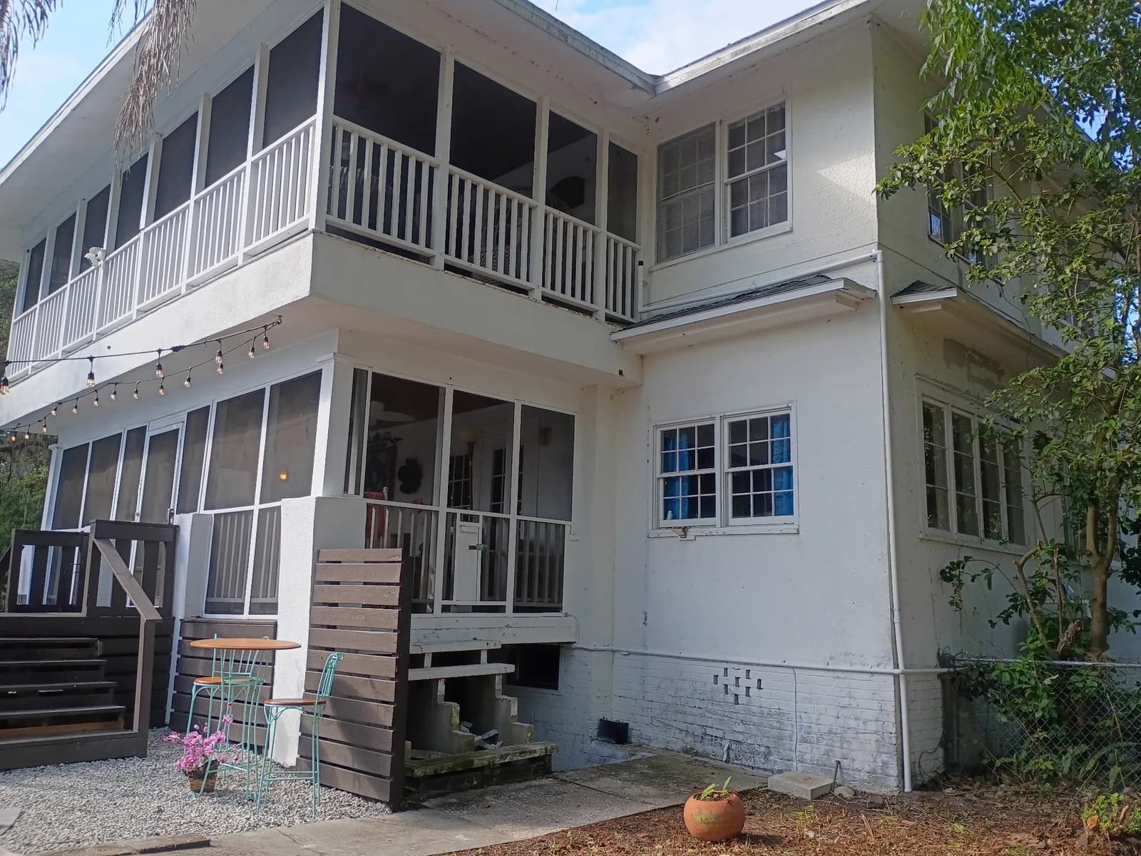 Two-story home rear after exterior work — fresh screened porch and deck