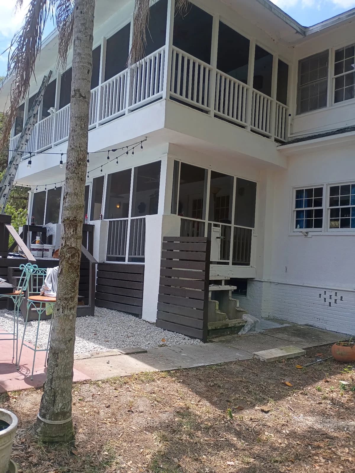 Two-story home rear after — freshly painted exterior with screened porches