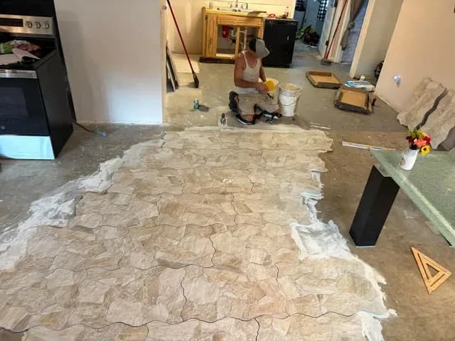 Stone-look tile being set over a concrete slab in a flagstone pattern