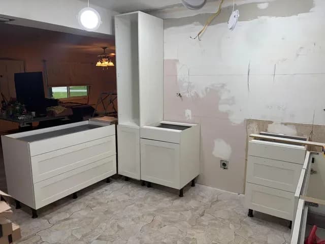 White shaker kitchen cabinets and a tall pantry cabinet going in along the wall