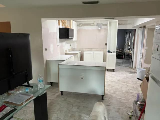 Open kitchen coming together, new island and white cabinets seen from the living room
