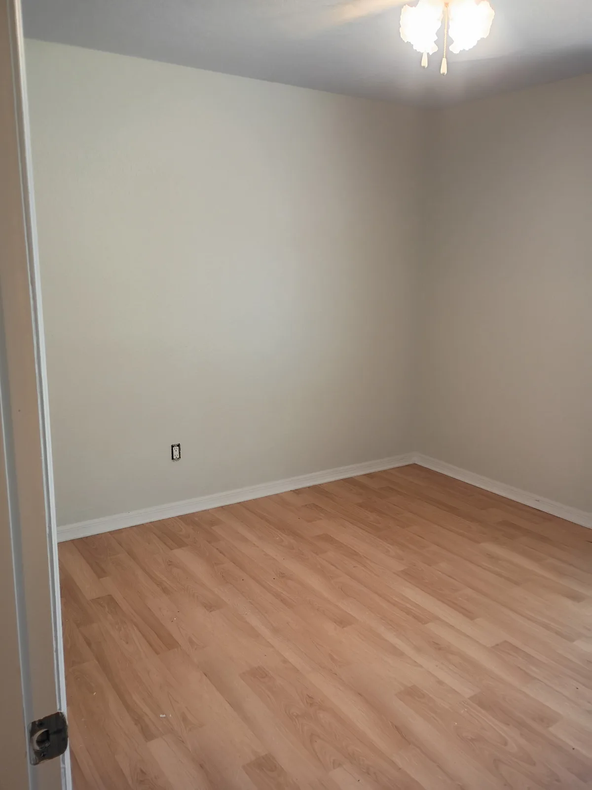 Bedroom after painting — warm gray walls with ceiling light
