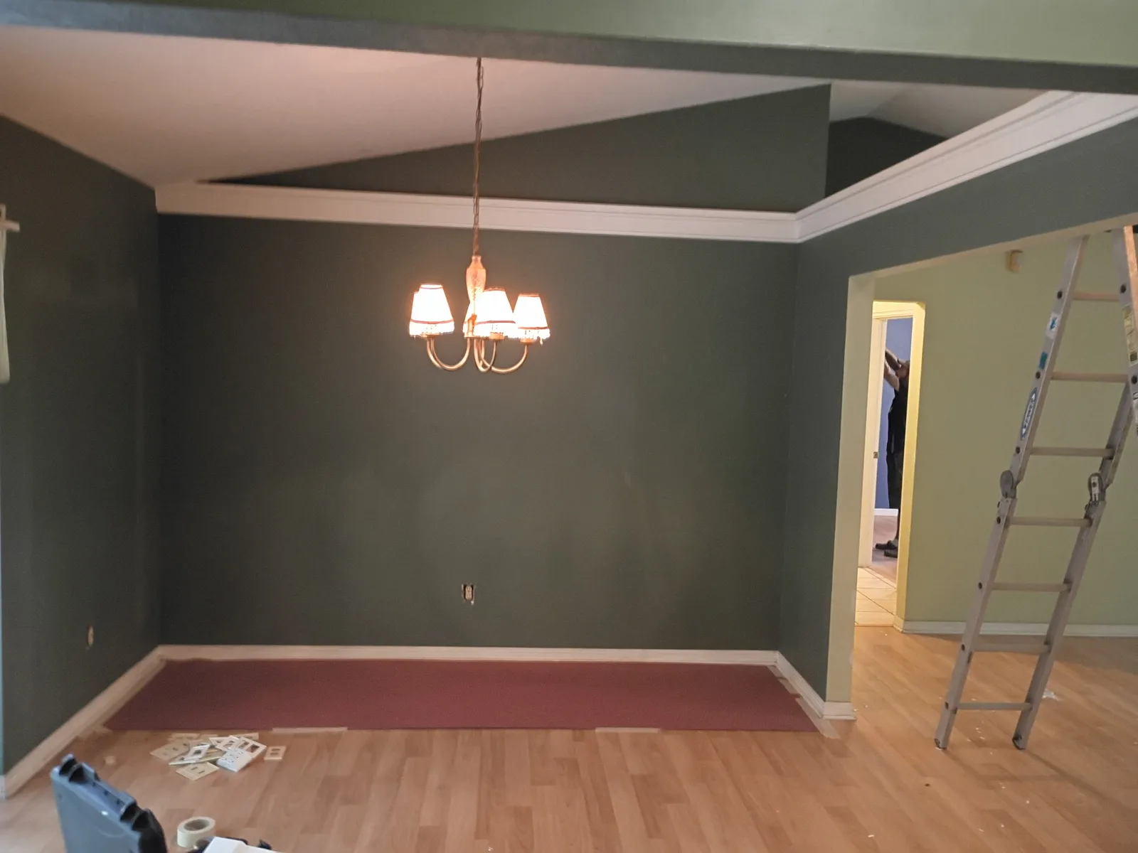 Dining room before painting — dark charcoal walls with chandelier