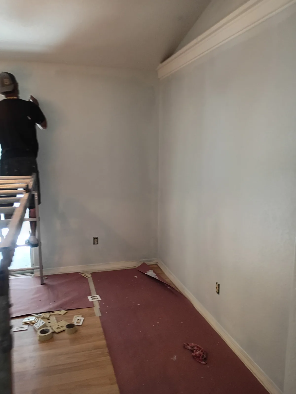 Jeff on ladder cutting in crown molding in living room