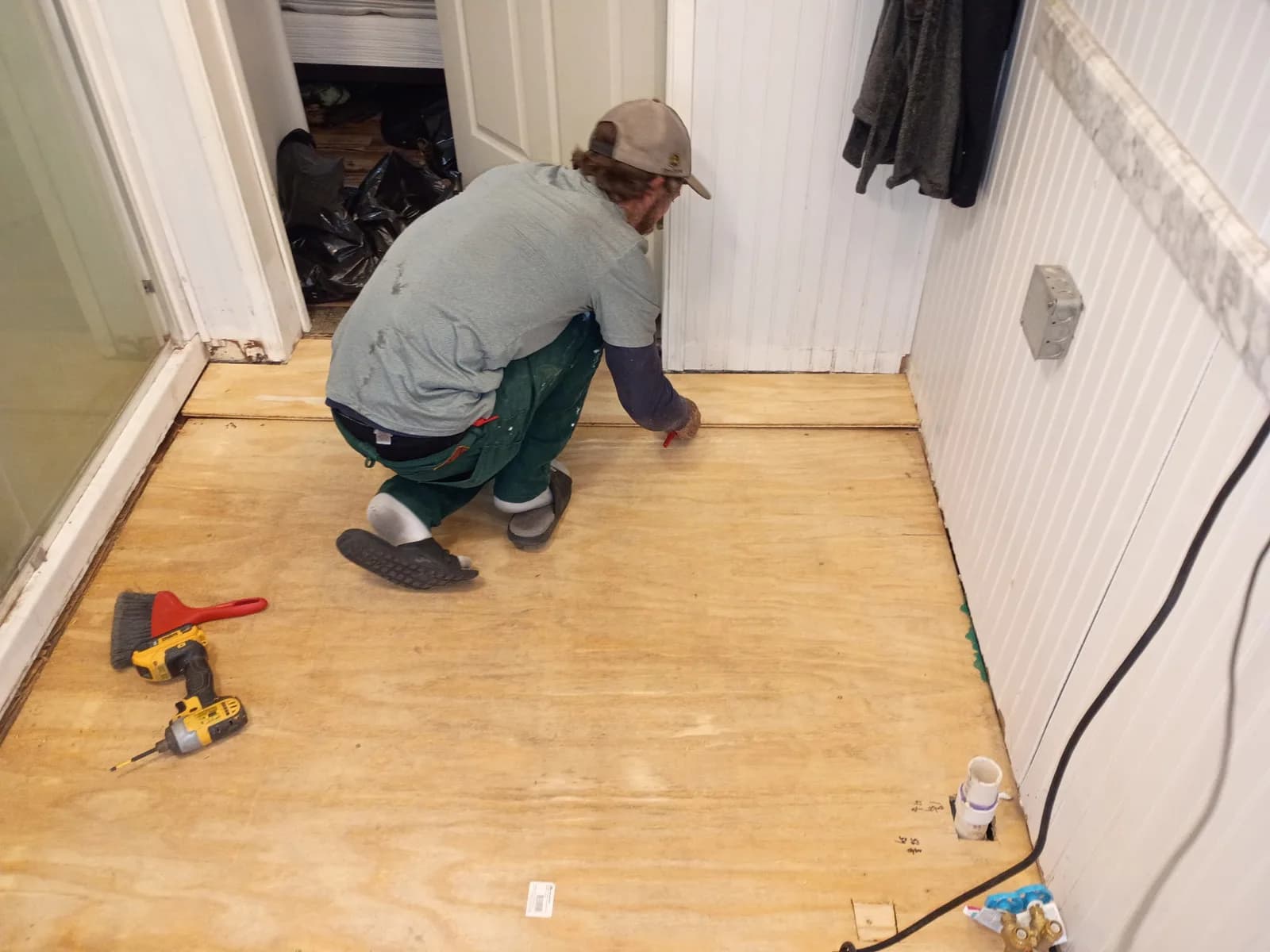 Jeff laying new plywood subfloor in bathroom renovation