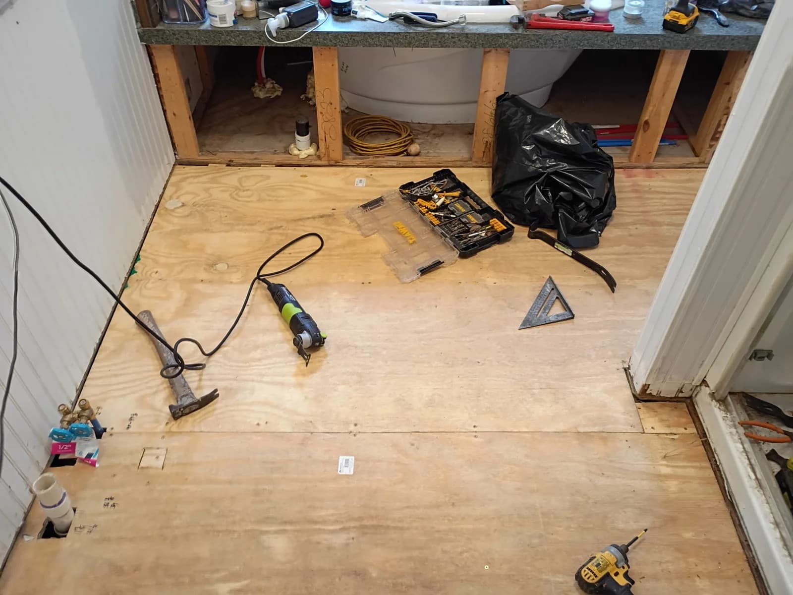 Bathroom vanity framing open — plumbing rough-in visible