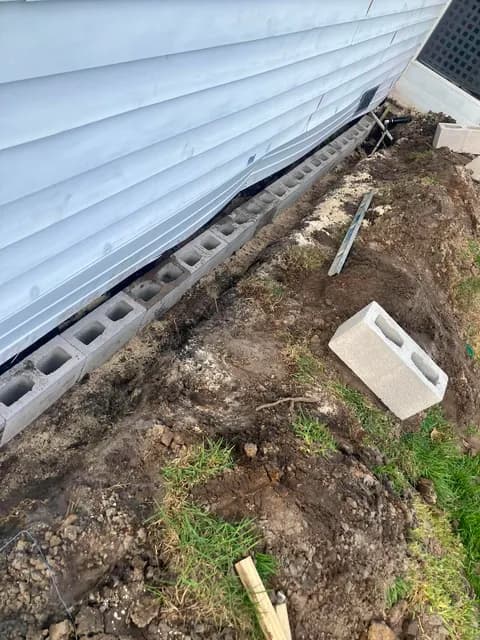 Cinder block footer laid in a trench to shore up a house foundation