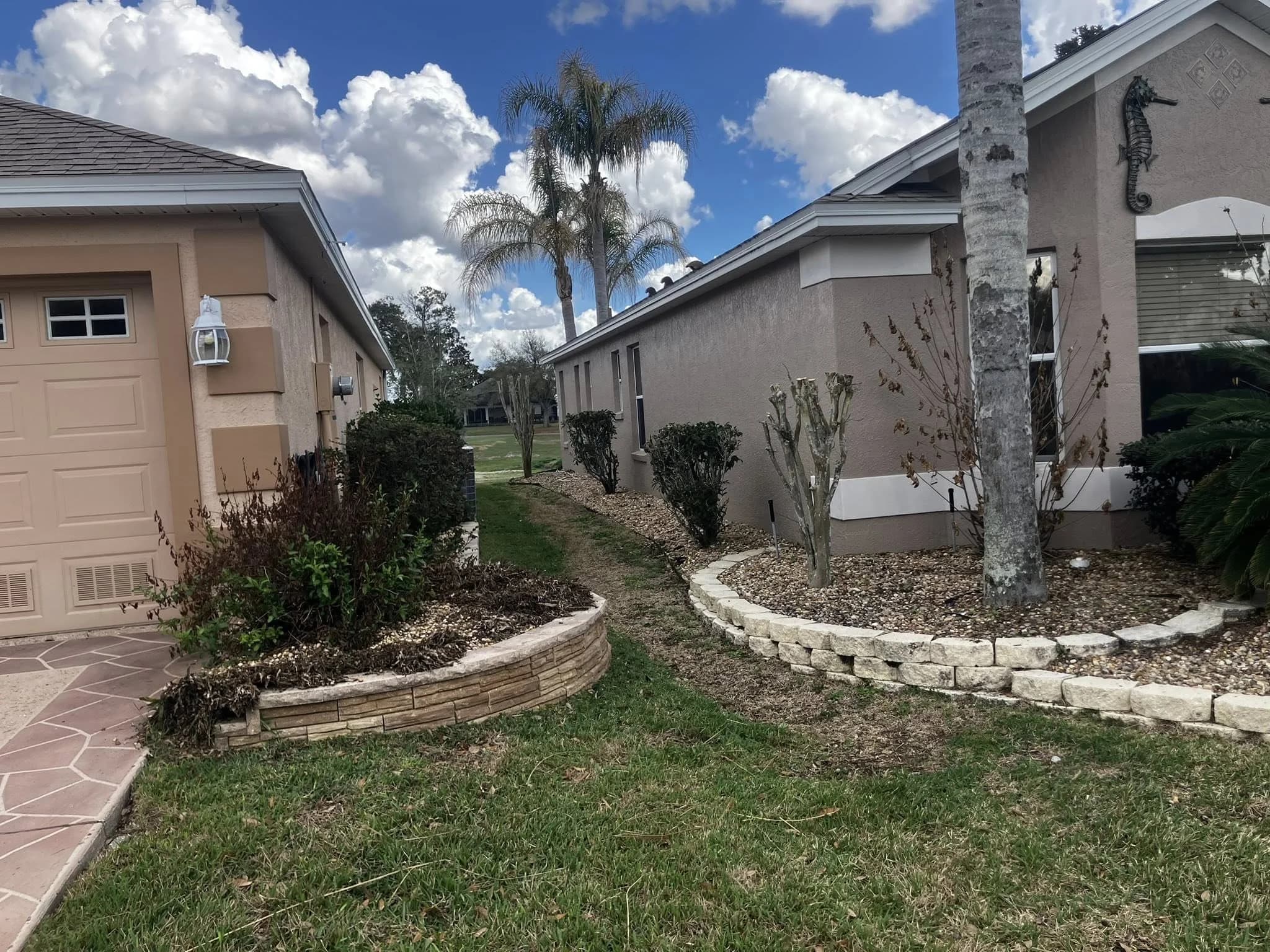 Clean stone border edging installed around lawn beds in a residential yard